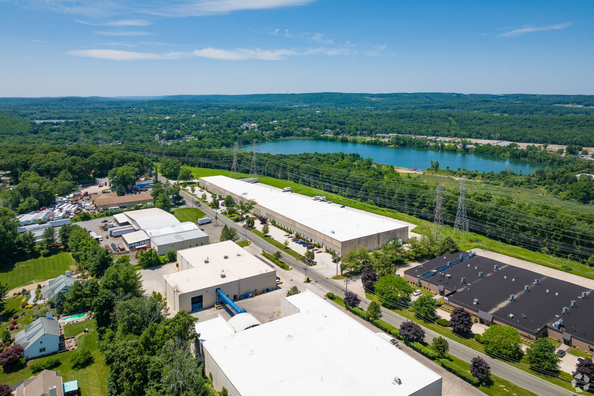 Aerial view of the AJJ Sales LLC facility in Mine Hill, NJ, surrounded by lakes, forest, and regional industrial infrastructure
